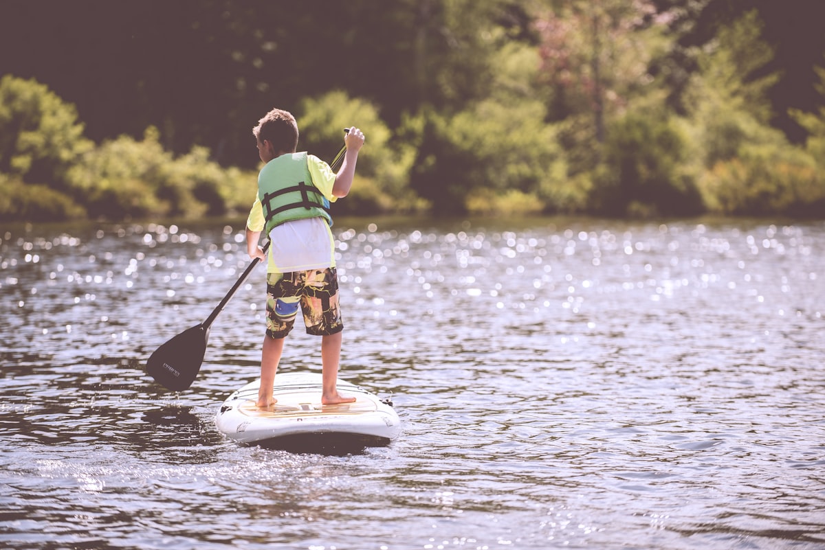 Family paddleboarding on calm lake water